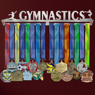 Gymnastics Medal Hanger Display FEMALE V1 showcasing up to 50 colorful medals on a brushed stainless steel rack with gymnast silhouettes.